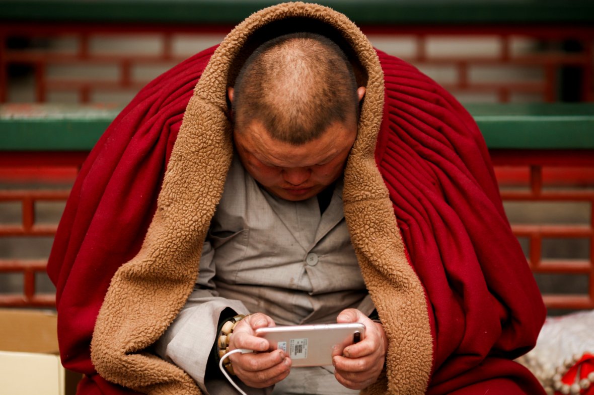 A man uses a smart phone at a Buddhist temple in Badachu park during Spring Festival celebrations marking Chinese New Year 