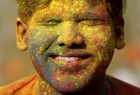 A student of Rabindra Bharati University, with his face smeared in coloured powder
