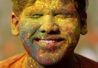 A student of Rabindra Bharati University, with his face smeared in coloured powder