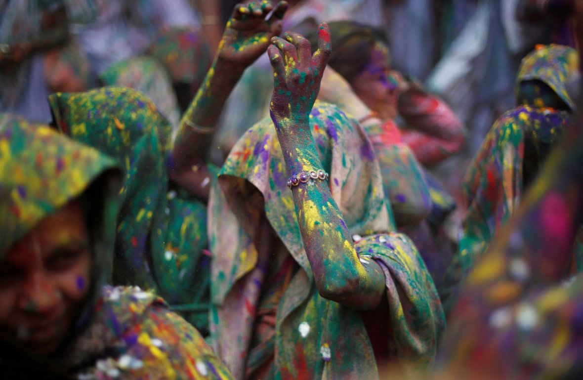 Widows daubed in colours dance as they take part in Holi celebrations in the town of Vrindavan