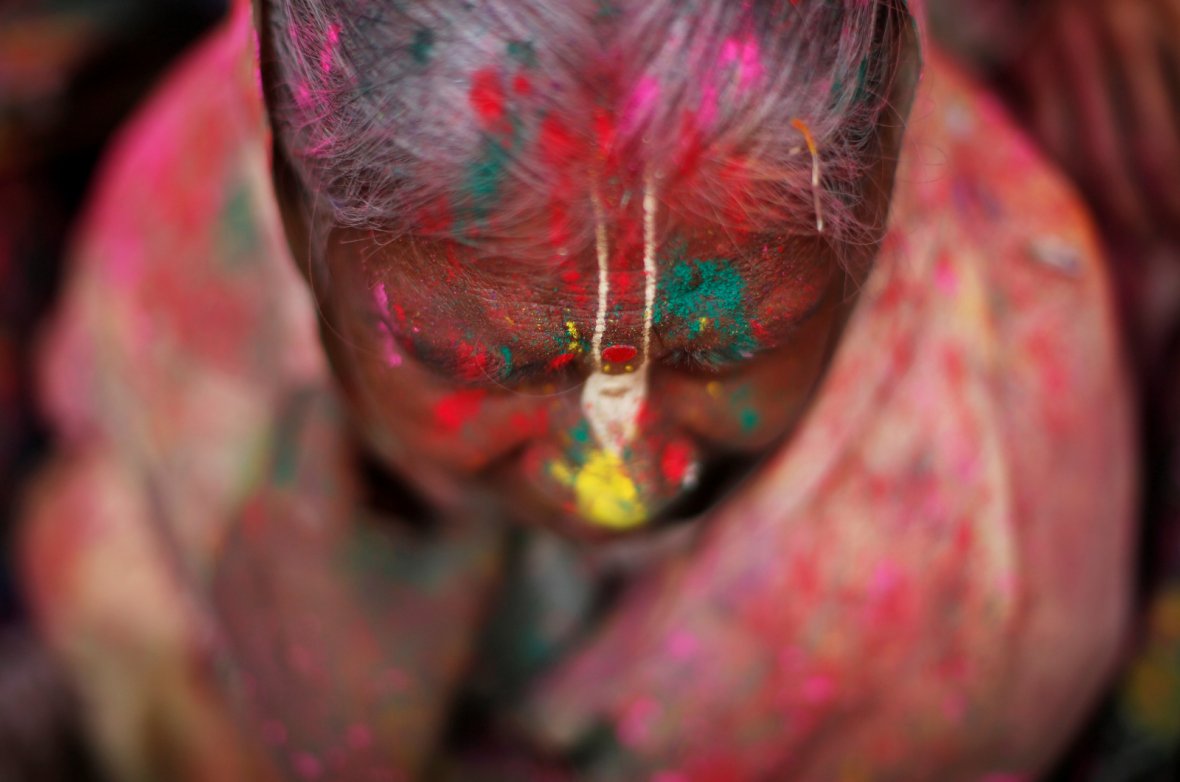 A widow daubed in colours takes part in Holi celebrations in the town of Vrindavan