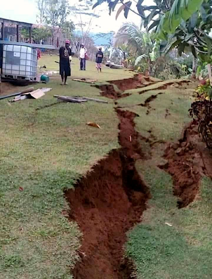 Papua New GuineaLocals stand next to a damaged house near a landslide
