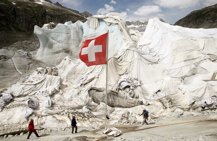 White canvas covers protect parts of the Rhone glacier against melting as visitors enter an ice cave near the Furka mountain pass 