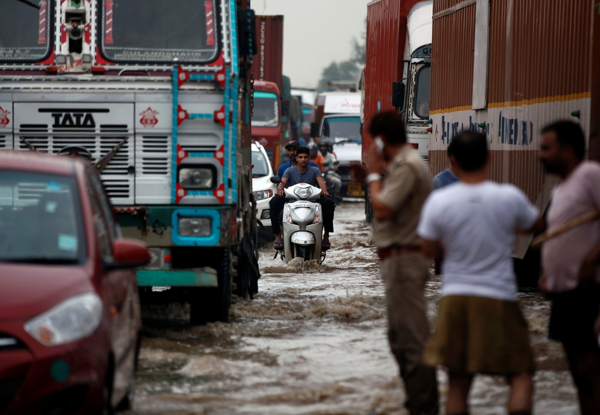 Vehicles wade through a waterlogged highway after heavy rains in the outskirts of New Delhi, India