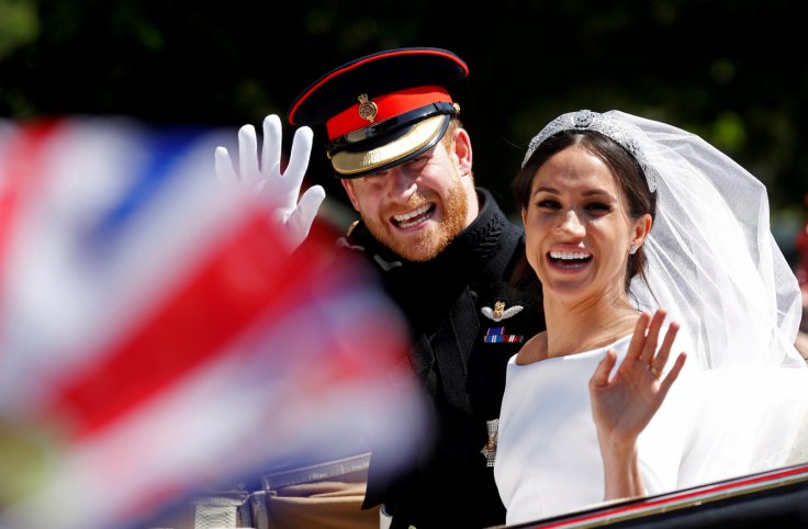 Britain’s Prince Harry and his wife Meghan wave as they ride a horse-drawn carriage after their wedding ceremony at St George’s Chapel in Windsor Castle in Windsor,