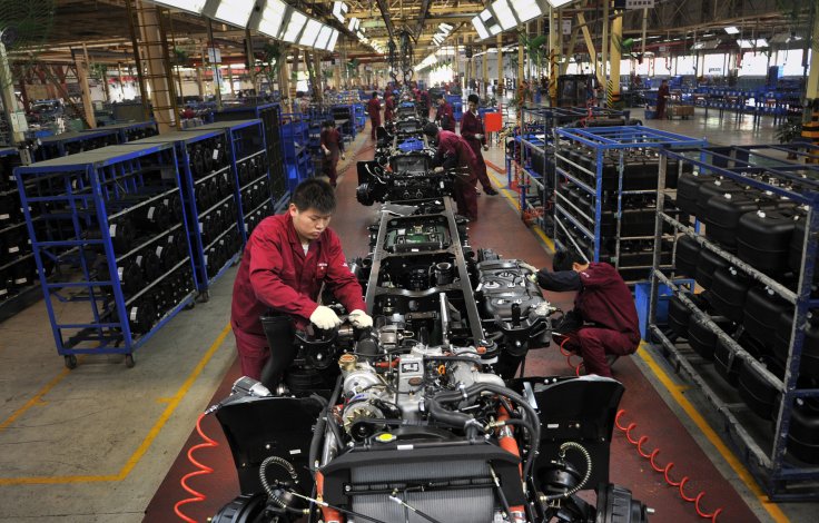 Workers install the chassis along a production line at a truck factory of Anhui Jianghuai Automobile Co. Ltd (JAC Motors) in Hefei, Anhui province