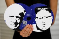 A worker of a media center for the summit between the U.S and North Korea shows fans featuring the images of U.S. President Donald Trump (L) and North Korean leader Kim Jong Un, which provided for journalists in a media kit at the media center in Singapor