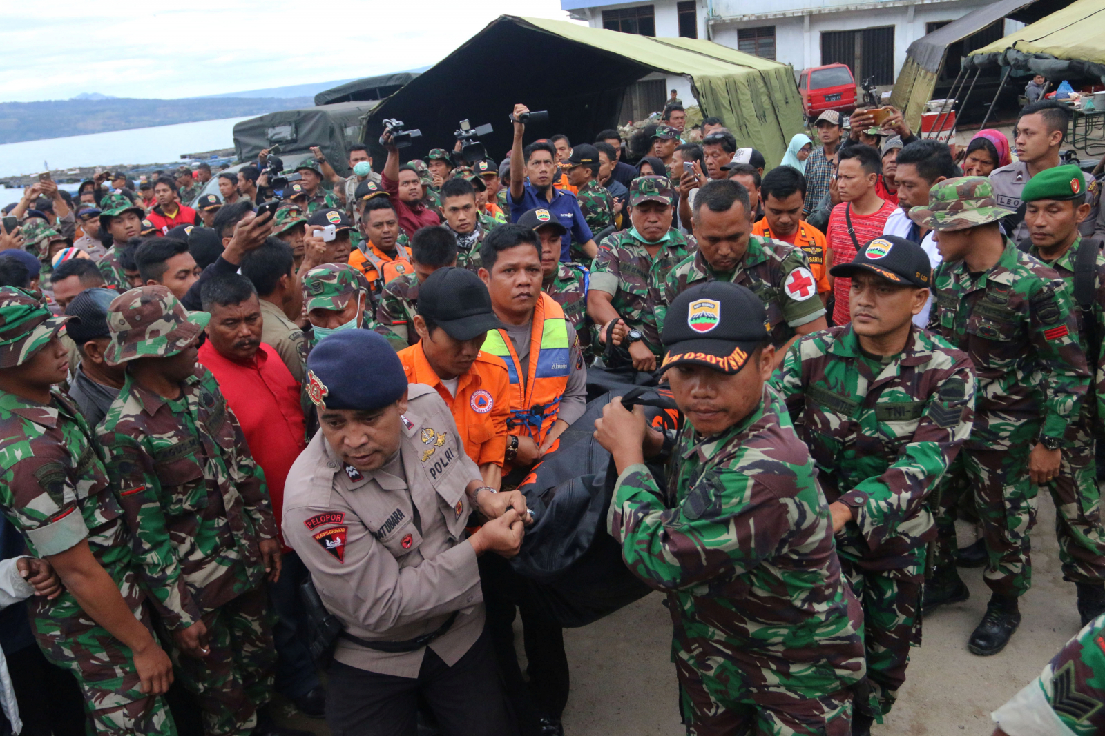 Indonesian security forces and rescue workers carry a victim recovered after a ferry sank in Lake Toba, at Tigaras Port in Simalungun, North Sumatra, Indonesia June 20, 2018 in this photo taken by Antara Foto.