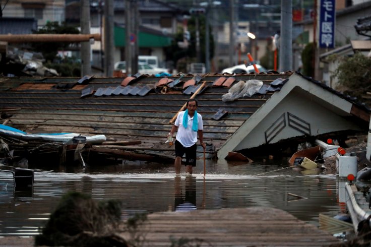 A local resident walks in front of submerged and destroyed houses in a flooded area in Mabi town in Kurashiki, Okayama Prefecture, Japan, July 8, 2018.