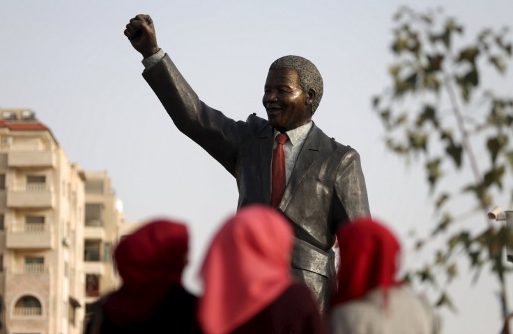 People look at the Mandela statue during the inauguration of Nelson Mandela Square in the West Bank city of Ramallah April 26, 2016. 