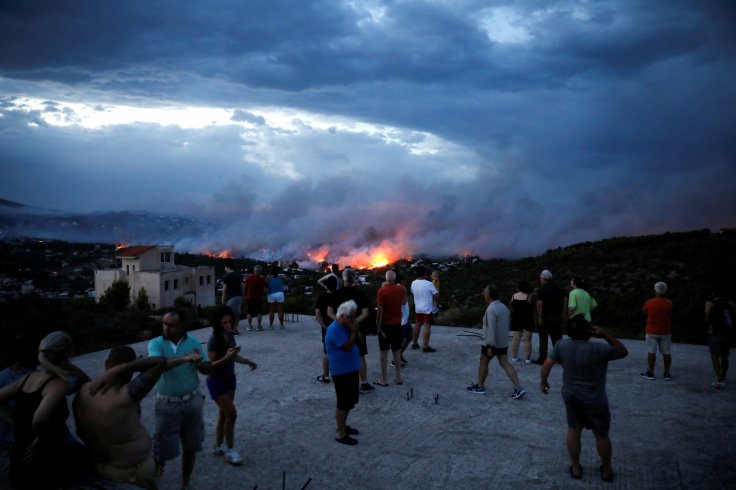 People watch a wildfire raging in the town of Rafina, near Athens, Greece, July 23, 2018. 