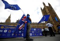 Anti-Brexit demonstrators wave EU and Union flags opposite the Houses of Parliament, in London