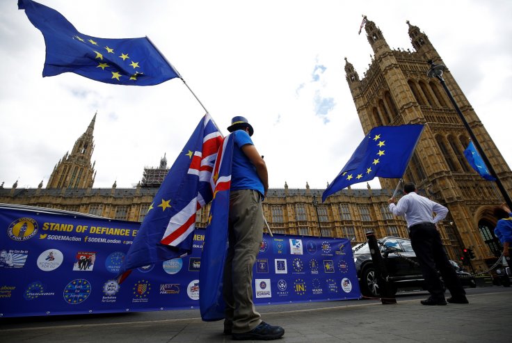 Anti-Brexit demonstrators wave EU and Union flags opposite the Houses of Parliament, in London