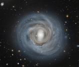 How far away is spiral galaxy NGC 4921? Although presently estimated to be about 310 million light years distant, a more precise determination could be coupled with its known recession speed to help humanity better calibrate the expansion rate of the enti