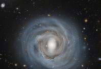 How far away is spiral galaxy NGC 4921? Although presently estimated to be about 310 million light years distant, a more precise determination could be coupled with its known recession speed to help humanity better calibrate the expansion rate of the enti