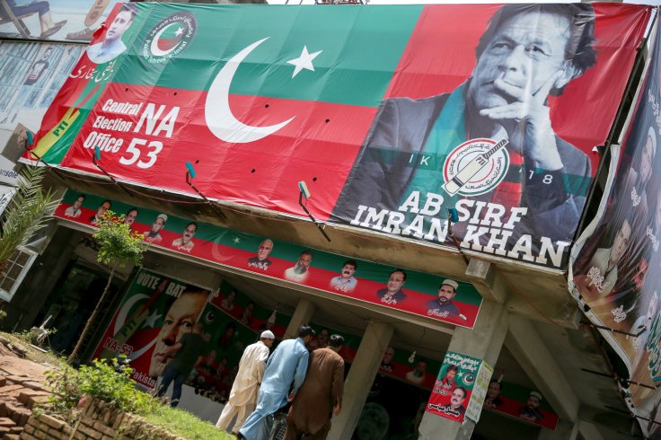 People walk past an image of cricket star-turned-politician Imran Khan, chairman of Pakistan Tehreek-e-Insaf (PTI) at a market in Islamabad, Pakistan, July 27, 2018. 