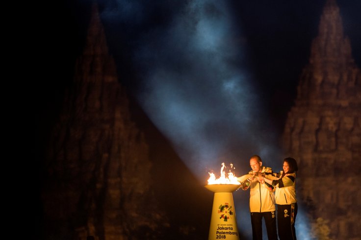 Indonesian badminton legend Susi Susanti (R) and former tennis star Yustedjo Tarik (L) light the torch during the 2018 Asian Games Torch Relay ceremony at Prambanan Temple complex, Sleman, Yogyakarta, Indonesia July 18, 2018 in this photo taken by Antara 