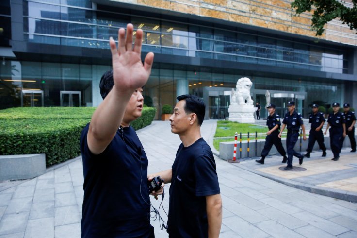  A police officer gestures at the photographer as security patrol outside the headquarters of China's banking regulator, to prevent planned protests by investors who lost money from collapsed peer-to-peer (P2P) online lending platforms, in Beijing, China 