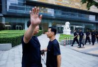 A police officer gestures at the photographer as security patrol outside the headquarters of China's banking regulator, to prevent planned protests by investors who lost money from collapsed peer-to-peer (P2P) online lending platforms, in Beijing, China A police officer gestures at the photographer as security patrol outside the headquarters of China's banking regulator, to prevent planned protests by investors who lost money from collapsed peer-to-peer (P2P) online lending platforms, in Beijing, China