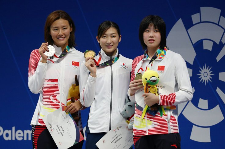 2018 Asian Games - Women's 50m Freestyle - GBK Aquatic Center, Jakarta, Indonesia - August 24, 2018 (L - R) China's Liu Xiang, Japan's Rikako Ikee and China's Wu Qingfeng celebrate with their medals after the Women's 50m Freestyle 