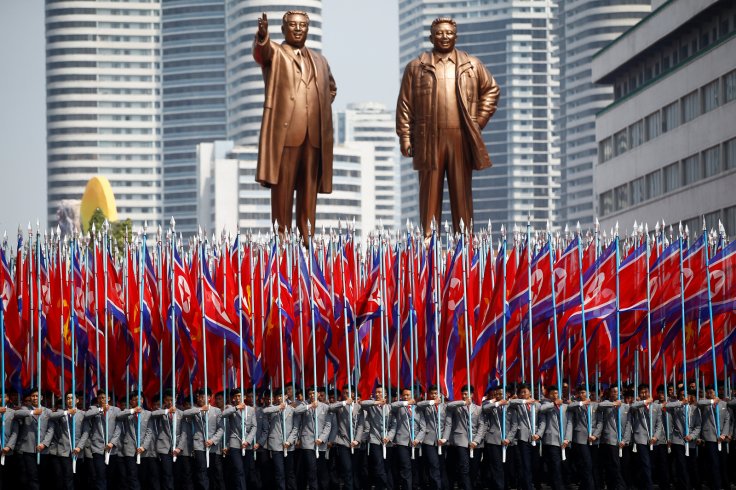 People carry flags in front of statues of North Korea founder Kim Il Sung (L) and late leader Kim Jong Il during a military parade marking the 105th birth anniversary Kim Il Sung, in Pyongyang April 15, 2017. REUTERS/Damir Sagolj/Files