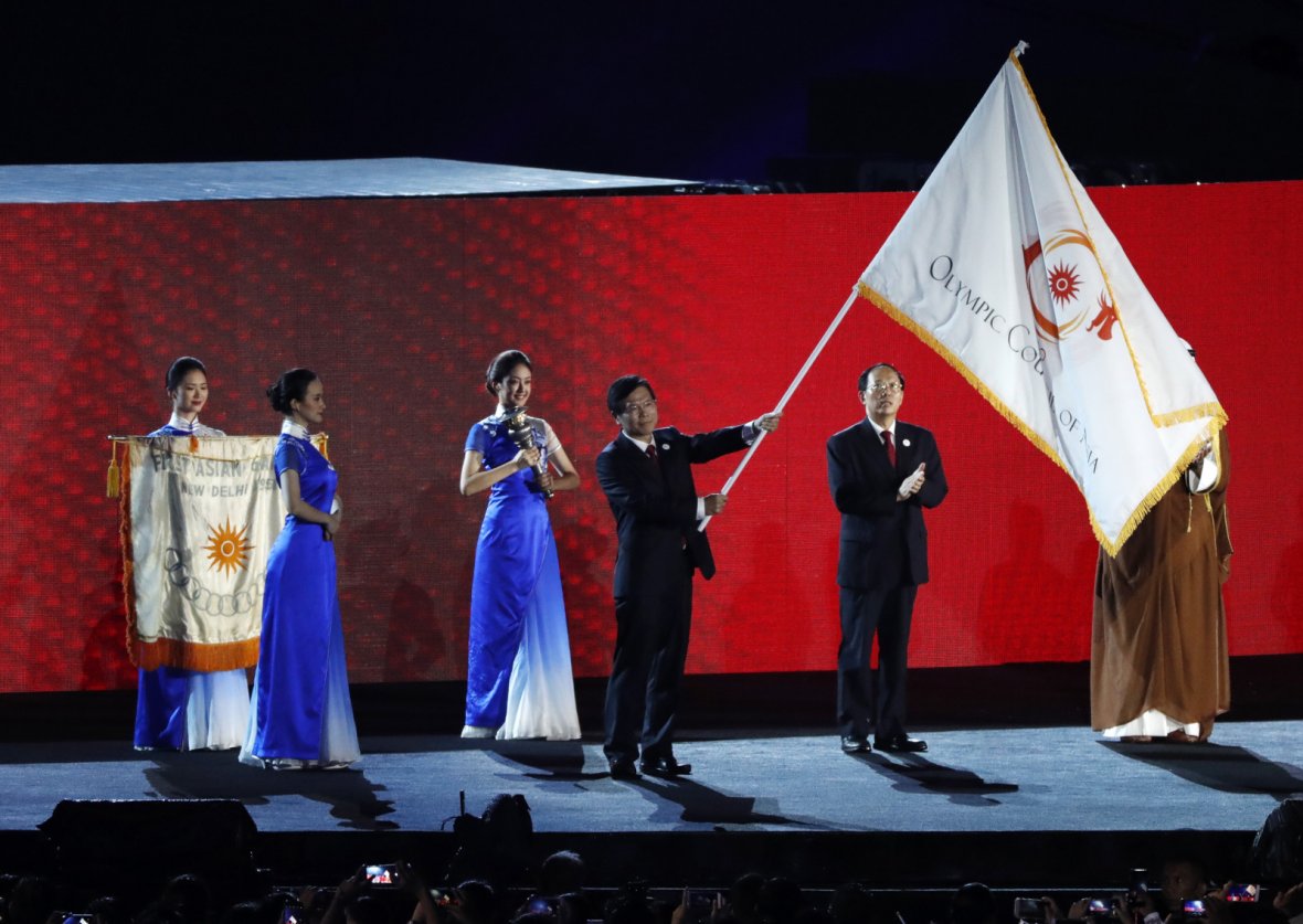 2018 Asian Games - Closing Ceremony - GBK Main Stadium - Jakarta, Indonesia - September 2, 2018 - A representative from China waves the Olympic Council of Asia flag after it was handed over by Indonesia. 