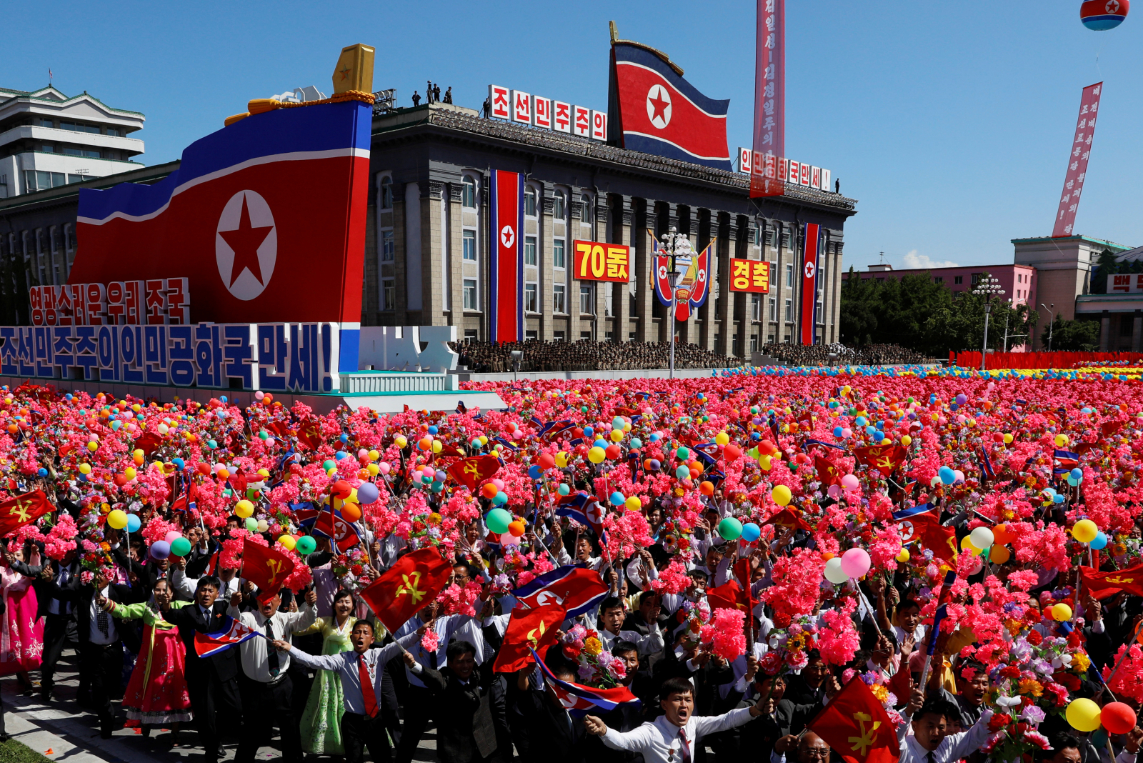 People wave plastic flowers and balloons during a military parade marking the 70th anniversary of North Korea's foundation in Pyongyang, North Korea, September 9, 2018. REUTERS/Danish Siddiqui