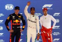 Formula One F1 - Singapore Grand Prix - Marina Bay Street Circuit, Singapore - September 15, 2018 Mercedes' Lewis Hamilton poses for a photograph on the podium after qualifying in pole position alongside second place Red Bull's Max Verstappen and third pl