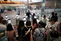 Passengers line-up at automated immigration control gates at Changi airport's Terminal 4 in Singapore April 30, 2018. Picture taken April 30, 2018. REUTERS/Thomas White