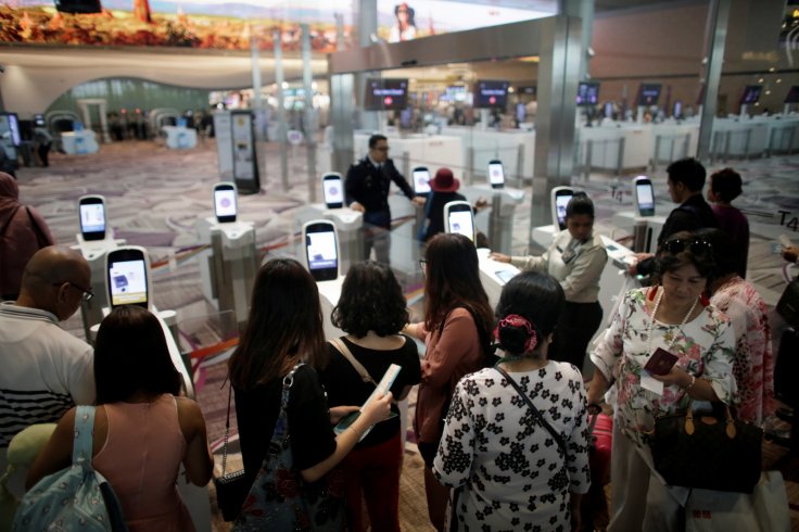Passengers line-up at automated immigration control gates at Changi airport's Terminal 4 in Singapore April 30, 2018. Picture taken April 30, 2018. REUTERS/Thomas White Passengers line-up at automated immigration control gates at Changi airport's Terminal 4 in Singapore April 30, 2018. Picture taken April 30, 2018. REUTERS/Thomas White