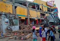 Residents stand in front of a damaged shopping mall after an earthquake hit Palu, Sulawesi Island, Indonesia September 29, 2018. Antara Foto/Rolex Malaha via REUTERS Residents stand in front of a damaged shopping mall after an earthquake hit Palu, Sulawesi Island, Indonesia September 29, 2018. Antara Foto/Rolex Malaha via REUTERS