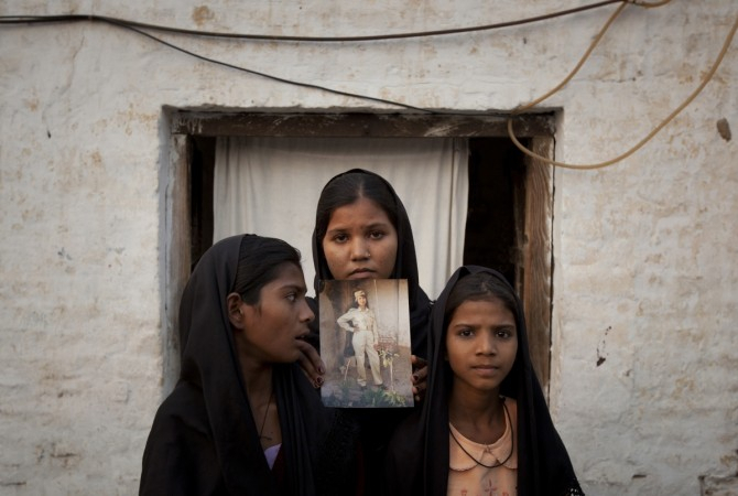 The daughters of Pakistani Christian woman Asia Bibi pose with an image of their mother outside their residence in Sheikhupura located in Pakistan's Punjab ProvinceReuters