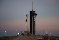 A SpaceX Falcon 9 rocket with the company’s Crew Dragon spacecraft onboard is seen after being raised into a vertical position on the launch pad at Launch Complex 39A as preparations continue for the Demo-1 mission, Feb. 28, 2019, at NASA’s Kennedy Space 