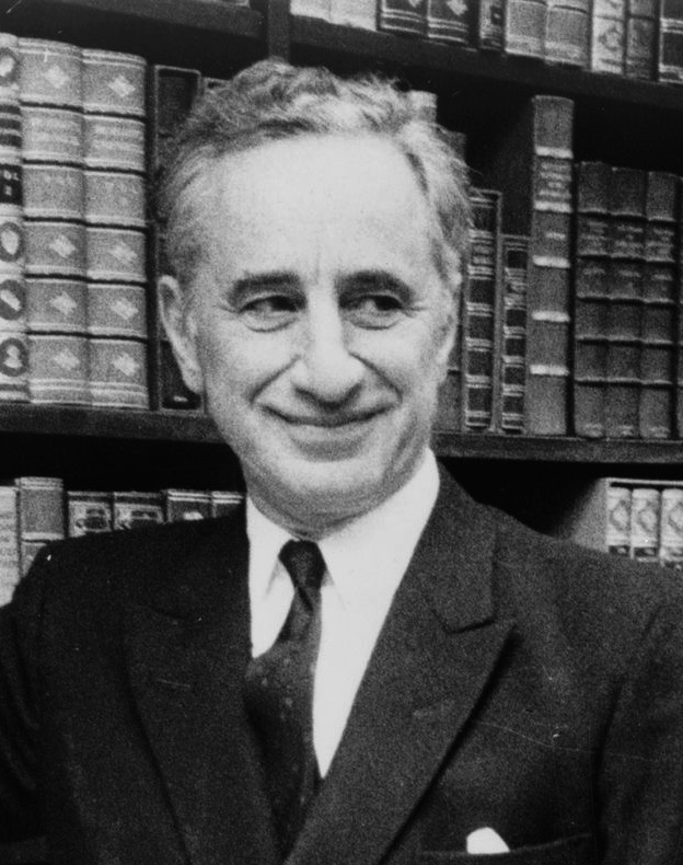 Elia Kazan standing before bookshelves at Brentano's book store