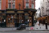 A man walks past a closed pub A man walks past a closed pub