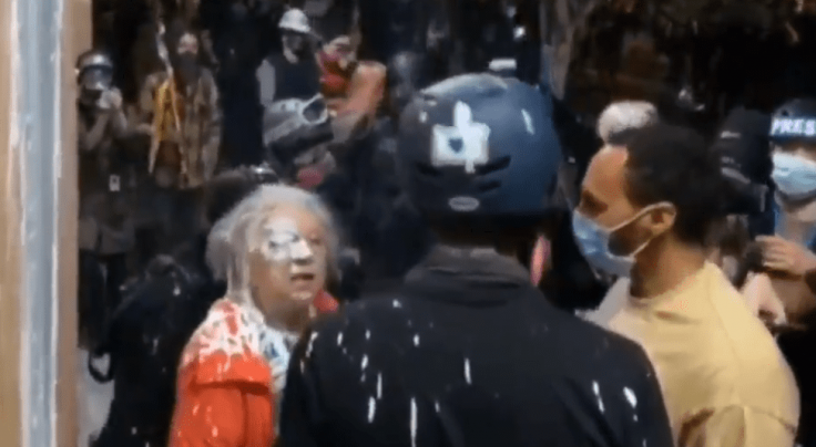 Protesters splash paint on Woman