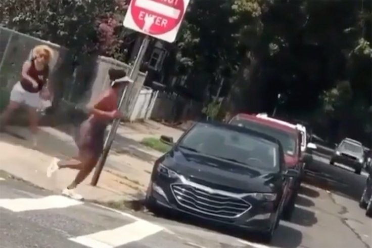 woman throws bottle at black jogger