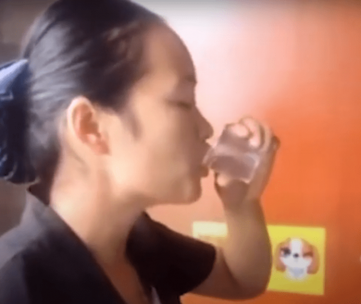 Woman cleaner drinks in toilet water