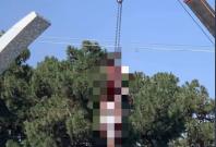Taliban hangs a body from an industrial crane