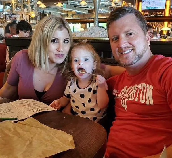 Sara Trost picture with her husband and 3-year-old daughter