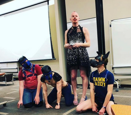 Image of Sam Brinton in American flag heels and a sparkly dress standing beside three people role-playing as dogs drew flak on social media