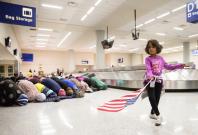 A young girl dances with an American flag