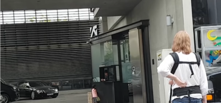 Four-year old girl talks to the guard of the YG Entertainment building