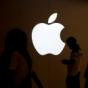 A man looks at the screen of his mobile phone in front of an Apple logo outside its store in Shanghai, China on July 30, 2017. A man looks at the screen of his mobile phone in front of an Apple logo outside its store in Shanghai, China on July 30, 2017.